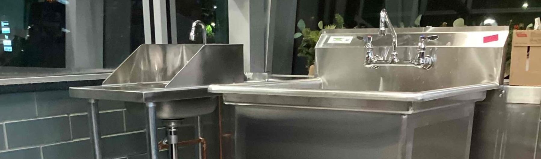 Stainless steel double sink setup in a modern industrial kitchen