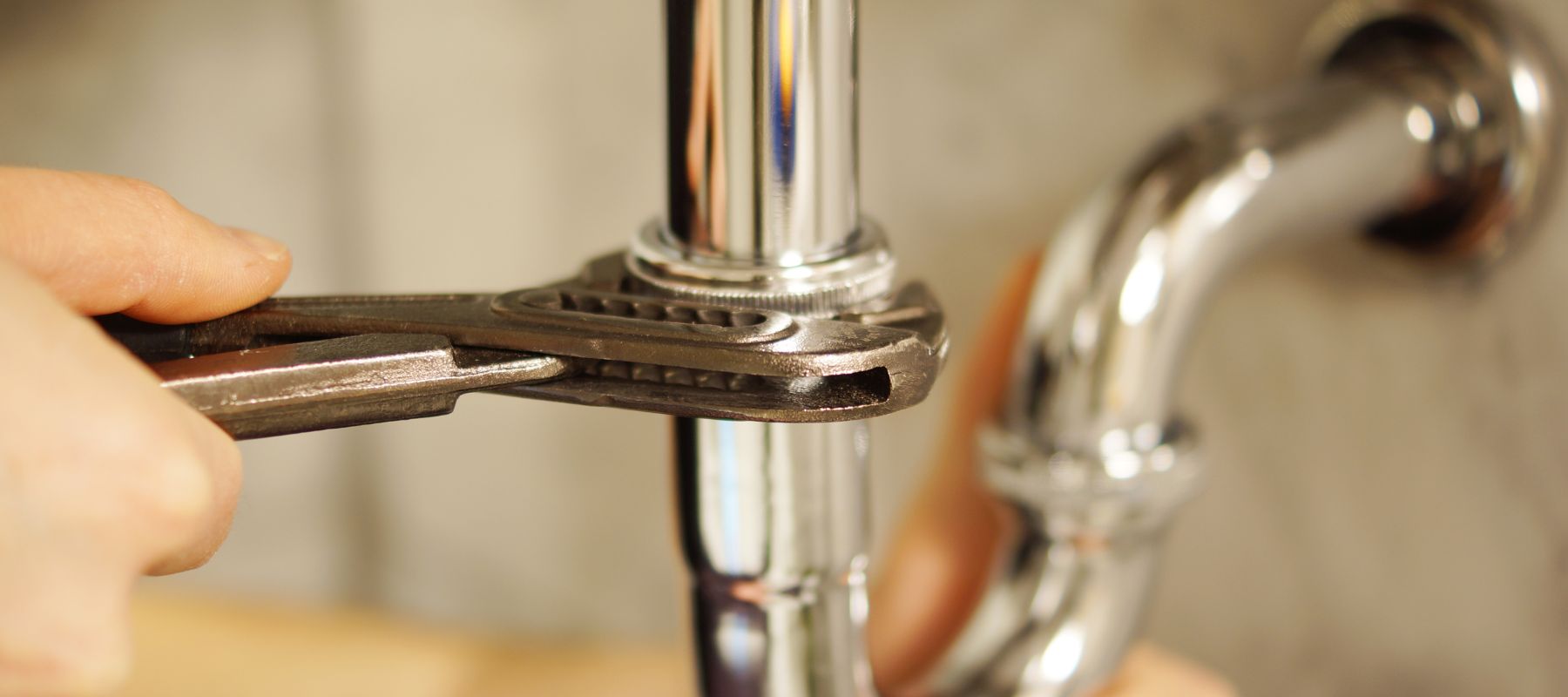 plumber using a wrench to tighten a pipe