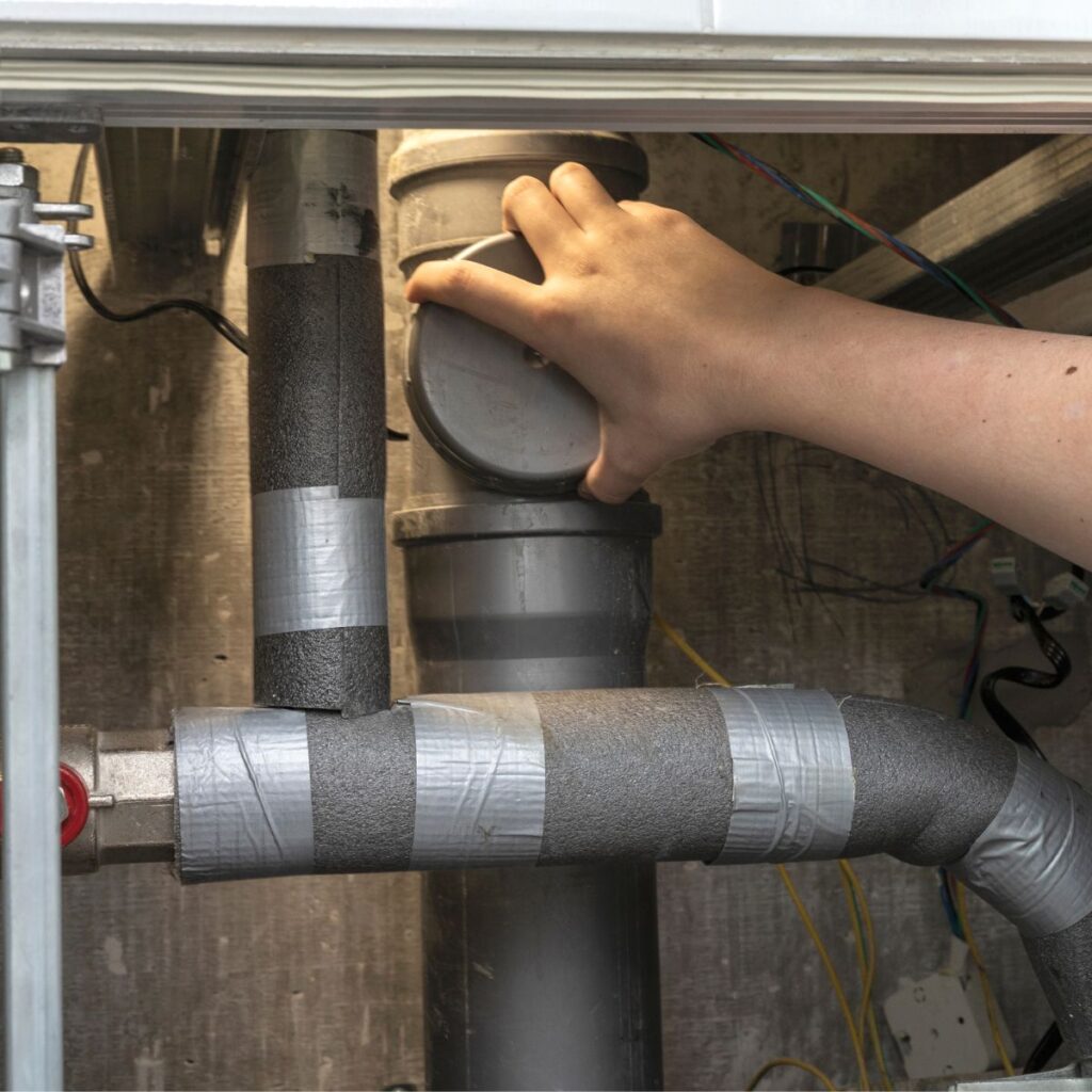 plumber unscrewing the cap on a pipe