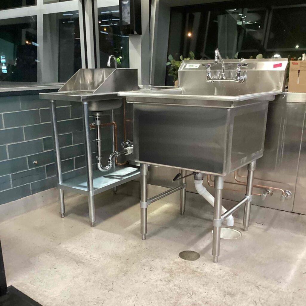 stainless steel double sink setup in a modern industrial kitchen